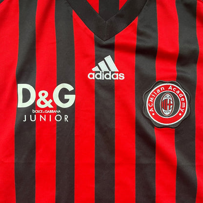 AC Milan Academy x Dolce &amp; Gabbana 2008/09 Home Tee is a black and red striped football shirt with black short sleeves. The chest features AC Milan Academy and Dolce &amp; Gabbana Junior logos on the sides, and a adidas logo in the center. Made with Clima365 technology.