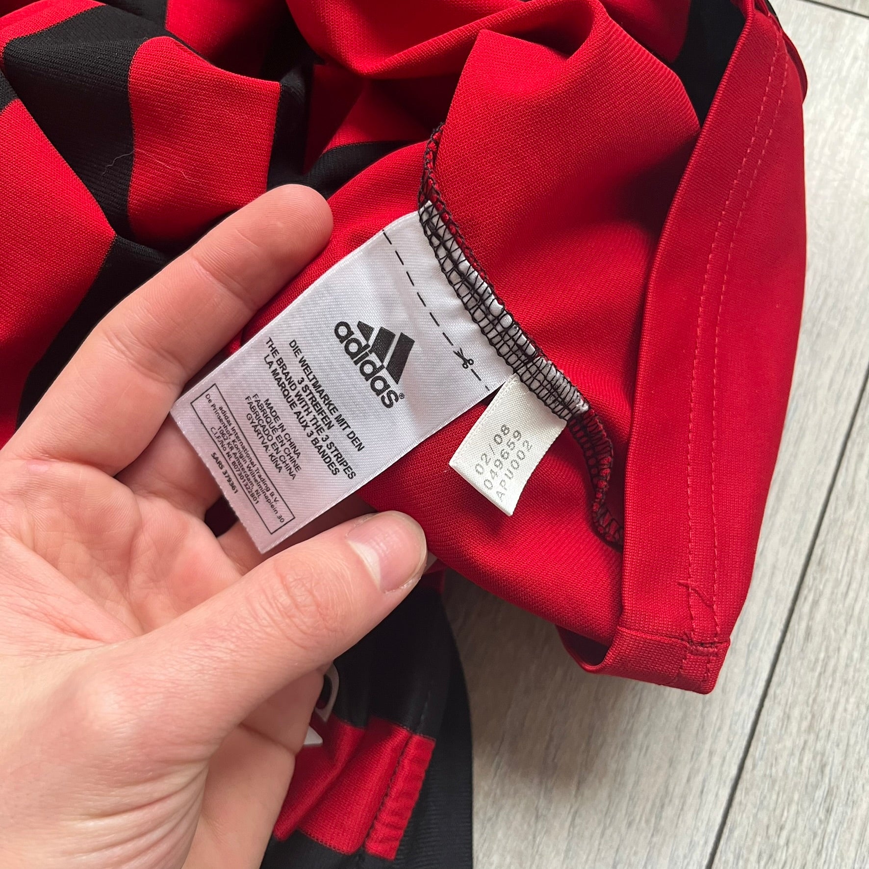 AC Milan Academy x Dolce &amp; Gabbana 2008/09 Home Tee is a black and red striped football shirt with black short sleeves. The chest features AC Milan Academy and Dolce &amp; Gabbana Junior logos on the sides, and a adidas logo in the center. Made with Clima365 technology.