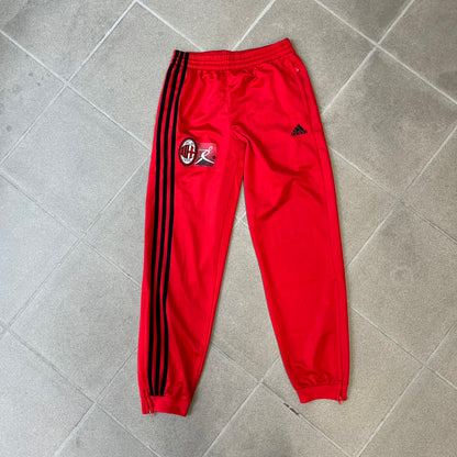 AC Milan x Adidas 2009/10 Junior Track Pants are a black and red junior football track bottoms with 3 black Adidas lines on the side. The right leg features AC Milan logo patch on one side, and Adidas logo embroidered on the left. Made with Climacool technology, it is designed for youth performance wear.