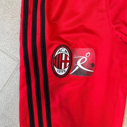 AC Milan x Adidas 2009/10 Junior Track Pants are a black and red junior football track bottoms with 3 black Adidas lines on the side. The right leg features AC Milan logo patch on one side, and Adidas logo embroidered on the left. Made with Climacool technology, it is designed for youth performance wear.