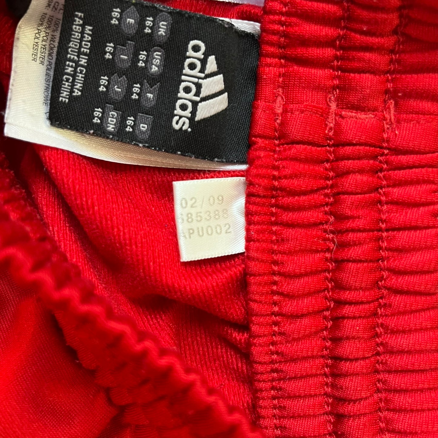 AC Milan x Adidas 2009/10 Junior Track Pants are a black and red junior football track bottoms with 3 black Adidas lines on the side. The right leg features AC Milan logo patch on one side, and Adidas logo embroidered on the left. Made with Climacool technology, it is designed for youth performance wear.