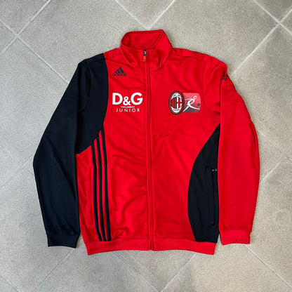 AC Milan x Dolce &amp; Gabbana 2009/10 Track Jacket is a black and red junior football track jacket with asymetrical black and red pattern. The chest features Adidas and D&amp;G Dolce &amp; Gabbana Junior logos on one side, and a AC Milan logo on the left. Made with Climacool technology, it is designed for youth performance wear.