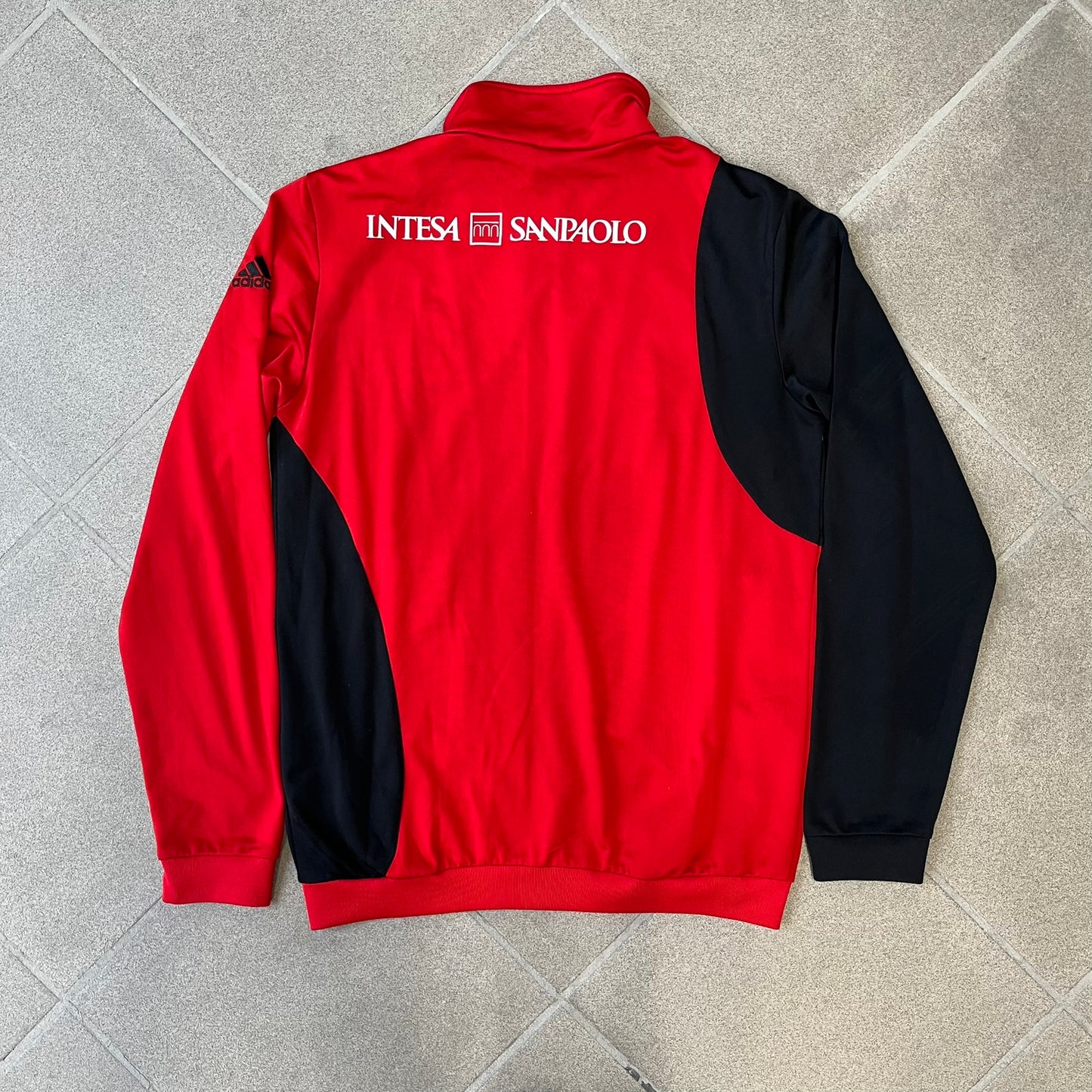 AC Milan x Dolce &amp; Gabbana 2009/10 Track Jacket is a black and red junior football track jacket with asymetrical black and red pattern. The chest features Adidas and D&amp;G Dolce &amp; Gabbana Junior logos on one side, and a AC Milan logo on the left. Made with Climacool technology, it is designed for youth performance wear.