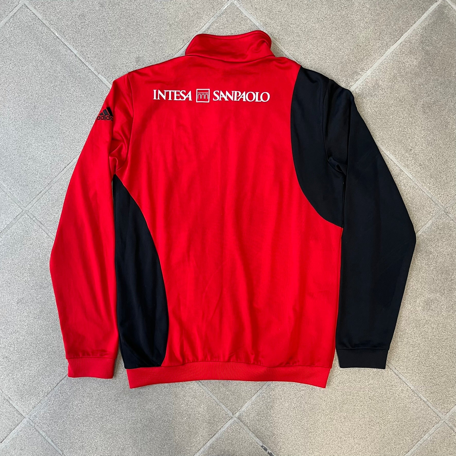 AC Milan x Dolce &amp; Gabbana 2009/10 Track Jacket is a black and red junior football track jacket with asymetrical black and red pattern. The chest features Adidas and D&amp;G Dolce &amp; Gabbana Junior logos on one side, and a AC Milan logo on the left. Made with Climacool technology, it is designed for youth performance wear.