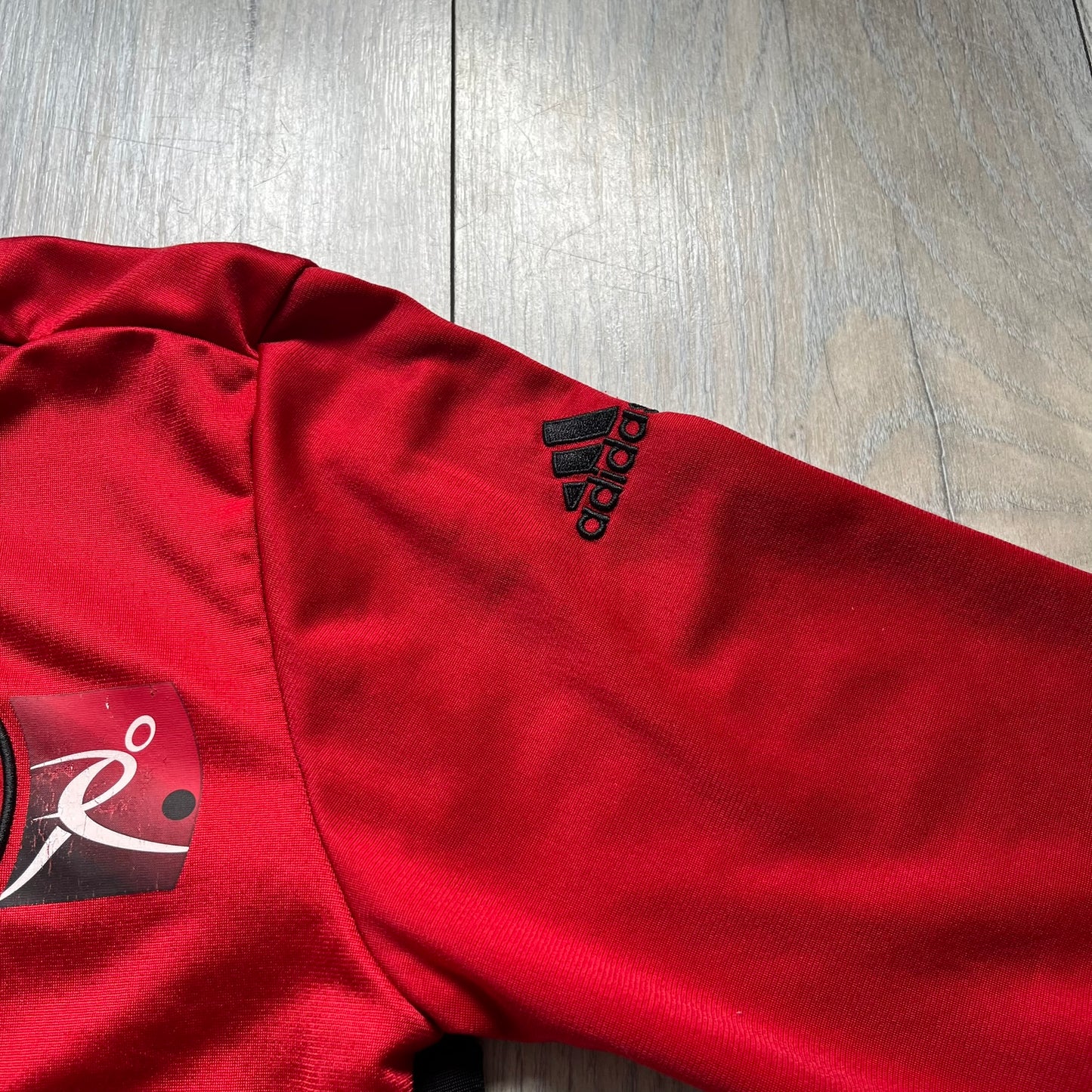 AC Milan x Dolce &amp; Gabbana 2009/10 Track Jacket is a black and red junior football track jacket with asymetrical black and red pattern. The chest features AC Milan and Adidas logos on one side, and a D&amp;G Dolce &amp; Gabbana Junior logo on the left. Made with Climacool technology, it is designed for youth performance wear.