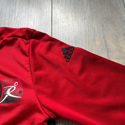 AC Milan x Dolce &amp; Gabbana 2009/10 Track Jacket is a black and red junior football track jacket with asymetrical black and red pattern. The chest features AC Milan and Adidas logos on one side, and a D&amp;G Dolce &amp; Gabbana Junior logo on the left. Made with Climacool technology, it is designed for youth performance wear.