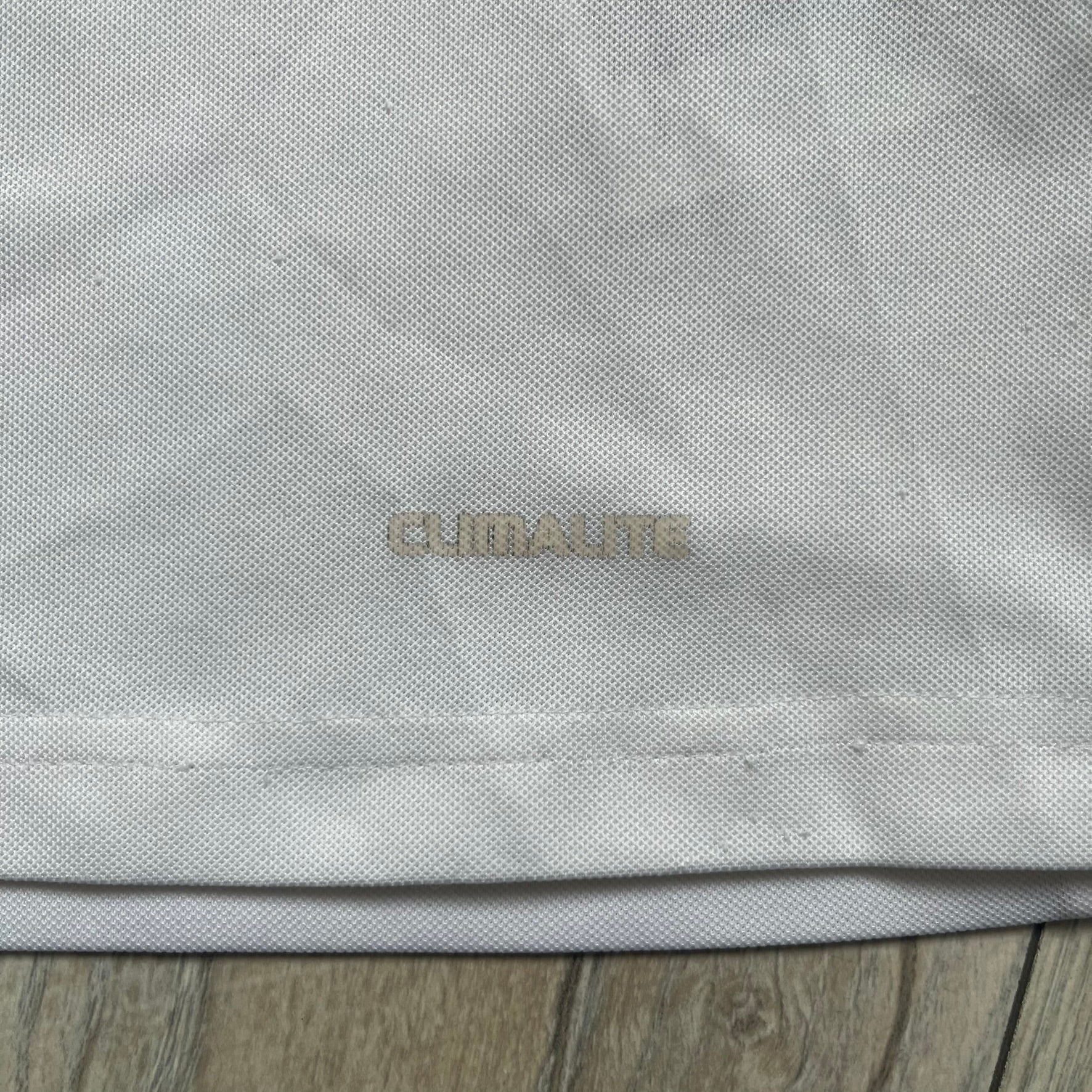 AC Milan x Dolce &amp; Gabbana 2009/10 Training Tee is a white football shirt with red ended short sleeves. The chest features AC Milan and Adidas logos on the sides, and a D&amp;G Dolce &amp; Gabbana Junior logo in the center. Made with Climalite technology, it is designed for performance wear.
