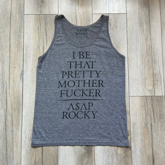 A$AP Rocky 2012 “Peso” Gray Tank Top is a grey sleeveless shirt sold at concerts during the early A$AP Rocky tours. The front features stacked text reading “I be that pretty mother fucker” arranged word-by-word from top to bottom, followed by a line and “ASAP Rocky” beneath. The neckline includes A$AP Rocky branding printed on the tag area.