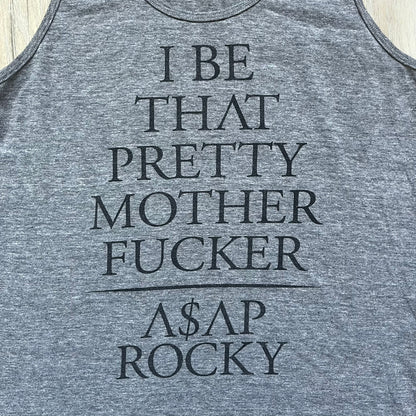 A$AP Rocky 2012 “Peso” Gray Tank Top is a grey sleeveless shirt sold at concerts during the early A$AP Rocky tours. The front features stacked text reading “I be that pretty mother fucker” arranged word-by-word from top to bottom, followed by a line and “ASAP Rocky” beneath. The neckline includes A$AP Rocky branding printed on the tag area.