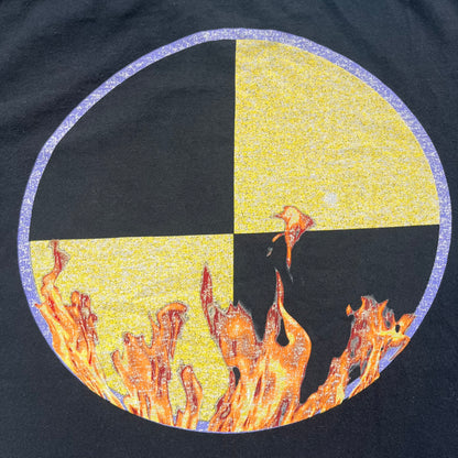 A$AP Rocky 2019 Injured Generation Tour “Crash Dummy” Tee is a black T-shirt released as part of the Injured Generation tour merchandise collection. The front features an illustrated crash dummy version of A$AP Rocky with “TESTING” text printed underneath. The opposite side includes a yellow and black burning TESTING logo graphic. Made in the USA.&nbsp;