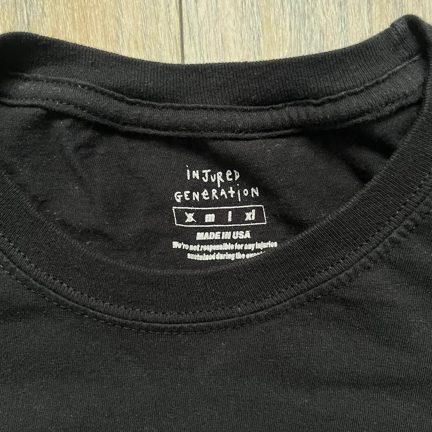 A$AP Rocky 2019 “Injured Generation” Tour “Pickpockets” Longsleeve is a black long-sleeve T-shirt released as part of the Injured Generation tour merchandise collection. The front features a large graphic of A$AP Rocky with green “Warning! Beware of Pickpockets” text. One sleeve includes “1-800-EAT-SHIT” text, while the other features a yellow and green testing-style logo. The back displays large green “Don’t Be a Dummy A$AP Rocky Europe” text layered over a white dummy mask graphic. Made in the USA.