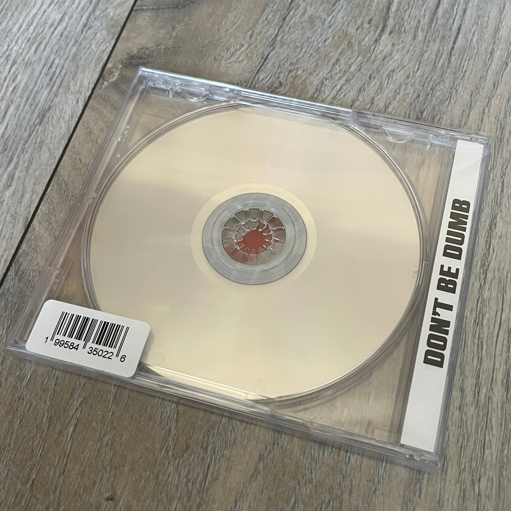 A$AP Rocky “Don’t Be Dumb” GRIM CD is a jewel case CD release of Don’t Be Dumb by A$AP Rocky featuring DUMMY artwork by Tim Burton. The cover includes large “Don’t Be Dumb” text with smaller “A$AP Rocky” and “Tim Burton Presents” above, along with the Dummy figure in a Dummy mask. The case spine features “Don’t Be Dumb” text, and the disc includes a foil design with a red crossed-out circle graphic.