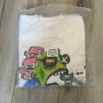 A$AP Rocky “Don’t Be Dumb” GR1M Short Sleeve Tee is a limited release from the AWGE website tied to the rollout of Don’t Be Dumb by A$AP Rocky. The white T-shirt features a green GR1M figure with a megaphone printed on the front with “GRIM” text below. The reverse includes a framed graphic with “Don’t Be Dumb” text, using a lenticular-style vinyl panel that shifts between the GR1M figure and A$AP Rocky in the same pose.
