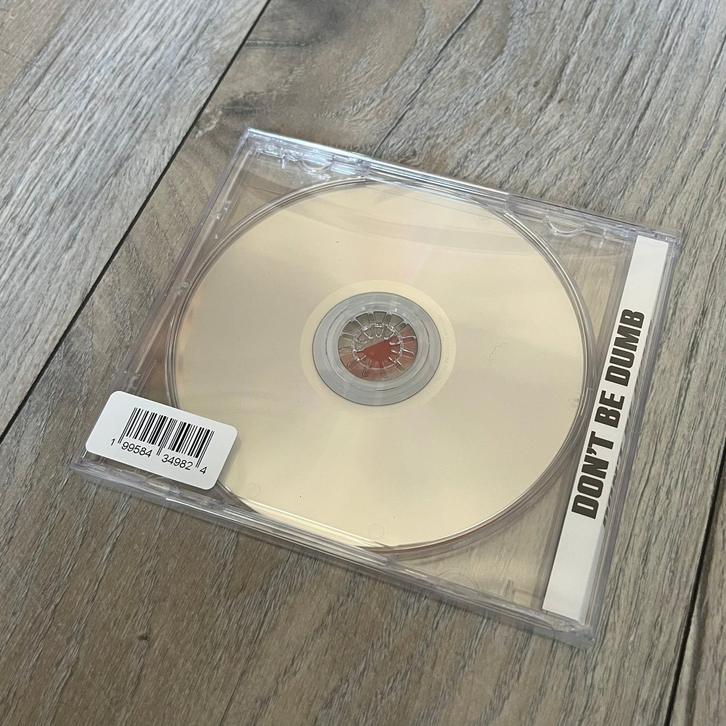 A$AP Rocky “Don’t Be Dumb” GRIM CD is a jewel case CD release of Don’t Be Dumb by A$AP Rocky featuring GRIM artwork by Tim Burton. The cover includes large “Don’t Be Dumb” text with smaller “A$AP Rocky” and “Tim Burton Presents” above, along with the GRIM figure holding a megaphone. The case spine features “Don’t Be Dumb” text, and the disc includes a foil design with a red crossed-out circle graphic.