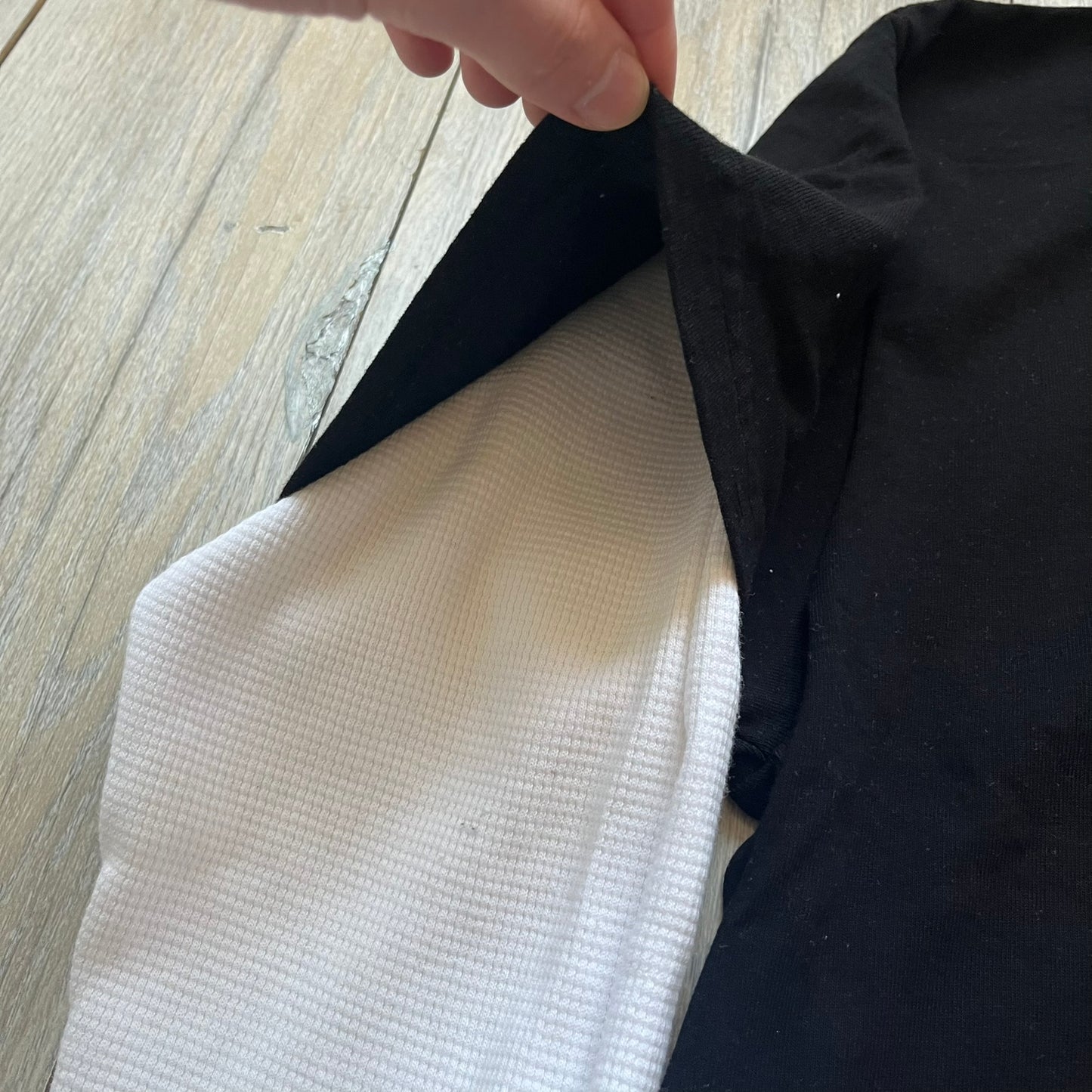 A$AP Rocky “Don’t Be Dumb” Mr Mayers Twofer Longsleeve is a limited release from the AWGE website tied to the rollout of Don’t Be Dumb by A$AP Rocky. The piece features a twofer construction with a black body and white sleeves, with a front graphic of the Mr Mayers figure in a blue trench coat with “Mr Mayers” text and small AWGE logos. The back includes a framed graphic with “Don’t Be Dumb” text, using a lenticular-style vinyl panel that shifts between the Mr Mayers figure and A$AP Rocky in the same outfit