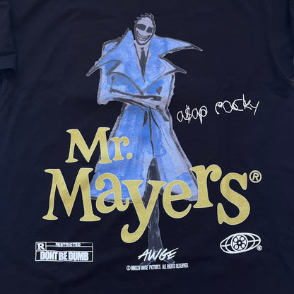 A$AP Rocky “Don’t Be Dumb” Mr Mayers Twofer Longsleeve is a limited release from the AWGE website tied to the rollout of Don’t Be Dumb by A$AP Rocky. The piece features a twofer construction with a black body and white sleeves, with a front graphic of the Mr Mayers figure in a blue trench coat with “Mr Mayers” text and small AWGE logos. The back includes a framed graphic with “Don’t Be Dumb” text, using a lenticular-style vinyl panel that shifts between the Mr Mayers figure and A$AP Rocky in the same outfit