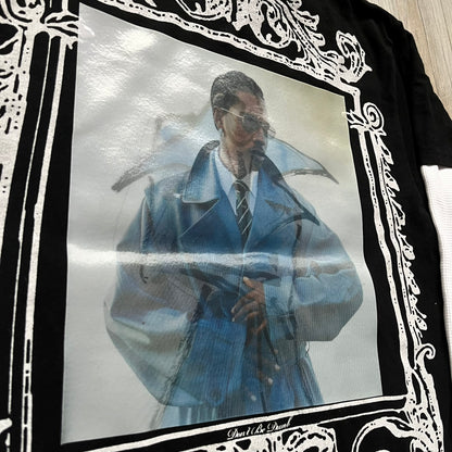 A$AP Rocky “Don’t Be Dumb” Mr Mayers Twofer Longsleeve is a limited release from the AWGE website tied to the rollout of Don’t Be Dumb by A$AP Rocky. The piece features a twofer construction with a black body and white sleeves, with a front graphic of the Mr Mayers figure in a blue trench coat with “Mr Mayers” text and small AWGE logos. The back includes a framed graphic with “Don’t Be Dumb” text, using a lenticular-style vinyl panel that shifts between the Mr Mayers figure and A$AP Rocky in the same outfit