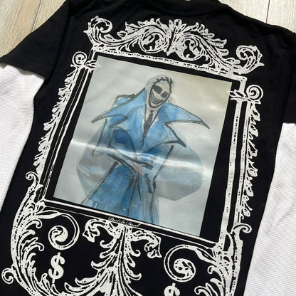 A$AP Rocky “Don’t Be Dumb” Mr Mayers Twofer Longsleeve is a limited release from the AWGE website tied to the rollout of Don’t Be Dumb by A$AP Rocky. The piece features a twofer construction with a black body and white sleeves, with a front graphic of the Mr Mayers figure in a blue trench coat with “Mr Mayers” text and small AWGE logos. The back includes a framed graphic with “Don’t Be Dumb” text, using a lenticular-style vinyl panel that shifts between the Mr Mayers figure and A$AP Rocky in the same outfit