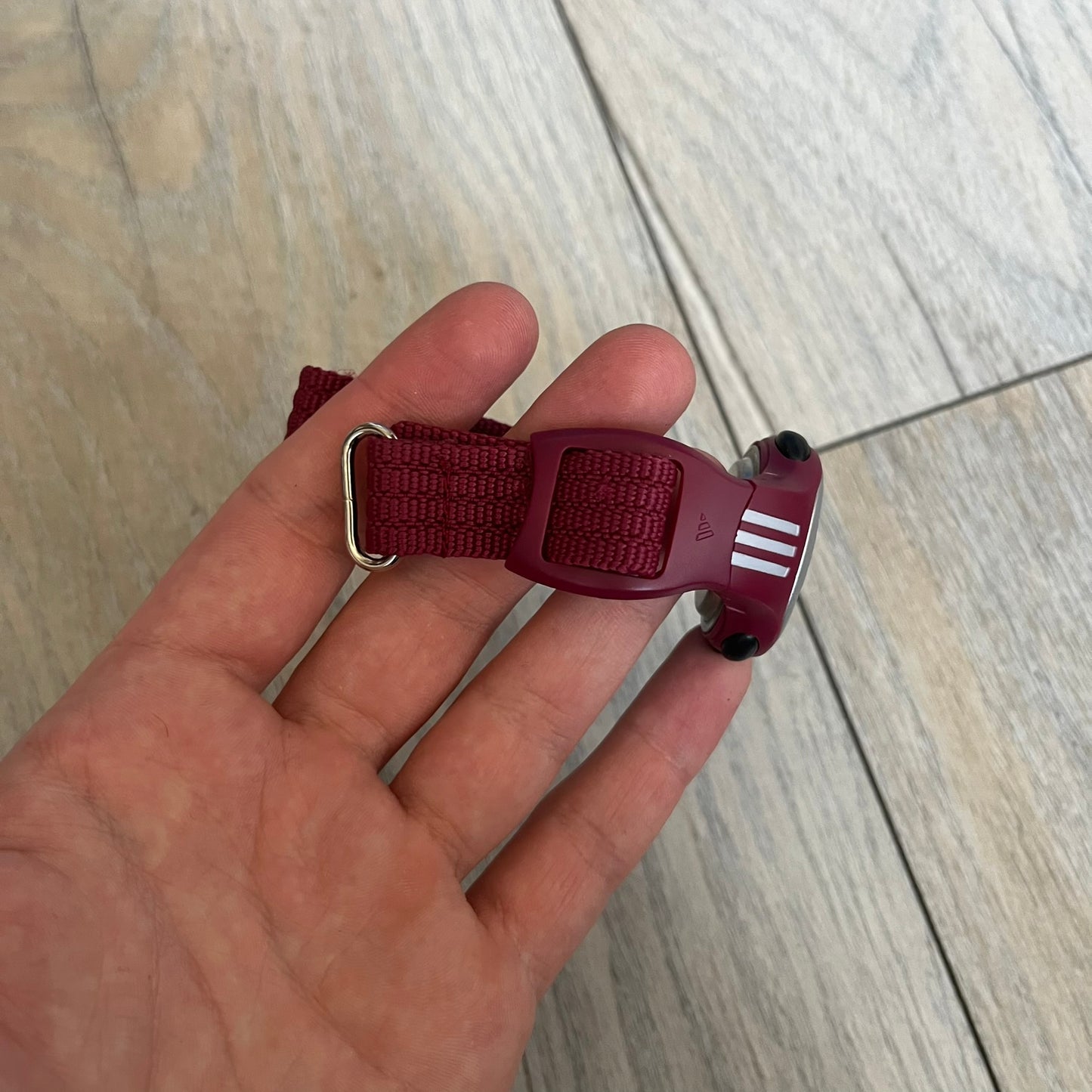 Adidas 2000s Burgundy 10-0117 Digital Watch (model X-003) is a burgundy digital watch with a silver bezel and ergonomic case. It features a burgundy nylon Velcro strap and four side buttons. The design includes three white stripes on the case and a silver Adidas logo button below the screen. The stainless steel back is engraved and marked water resistant up to 3 ATM, with an Adidas logo patch on the strap.