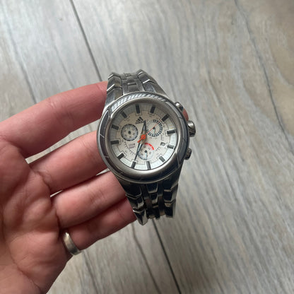 Adidas Adi-Star Pro Chrono ADP-1017 Analog Watch is a stainless steel timepiece with a white dial featuring the Adidas logo and three subdials for chronograph functions. It has two side buttons and a crown for adjustments, with a detailed and textured dial design. The watch is water resistant up to 200 meters.