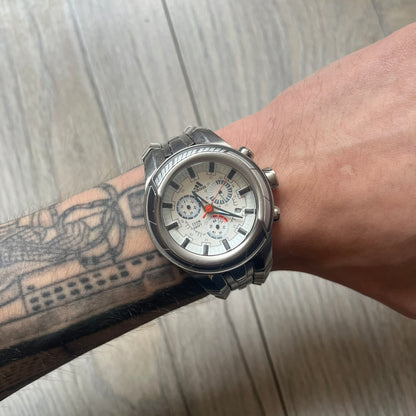 Adidas Adi-Star Pro Chrono ADP-1017 Analog Watch is a stainless steel timepiece with a white dial featuring the Adidas logo and three subdials for chronograph functions. It has two side buttons and a crown for adjustments, with a detailed and textured dial design. The watch is water resistant up to 200 meters.