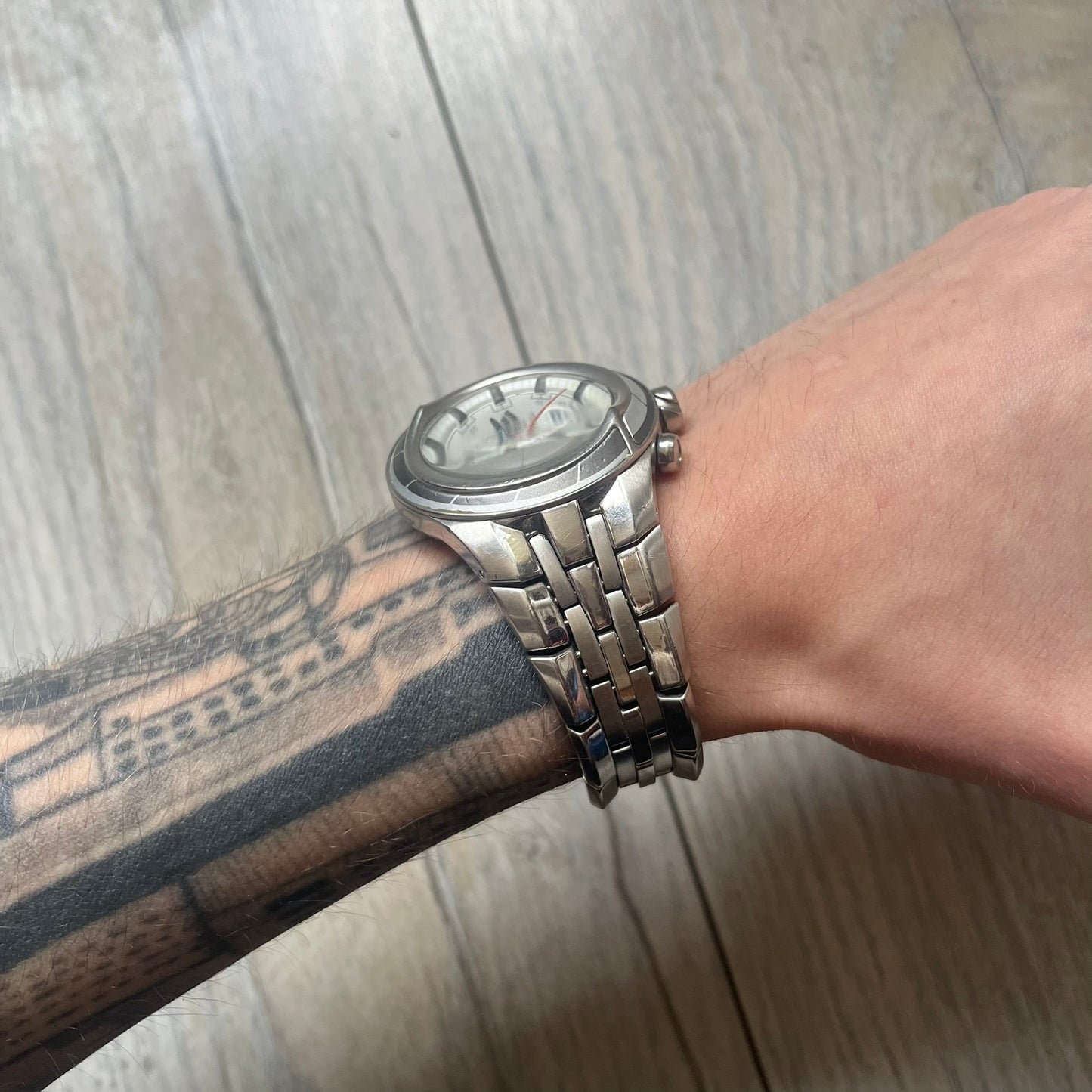 Adidas Adi-Star Pro Chrono ADP-1017 Analog Watch is a stainless steel timepiece with a white dial featuring the Adidas logo and three subdials for chronograph functions. It has two side buttons and a crown for adjustments, with a detailed and textured dial design. The watch is water resistant up to 200 meters.