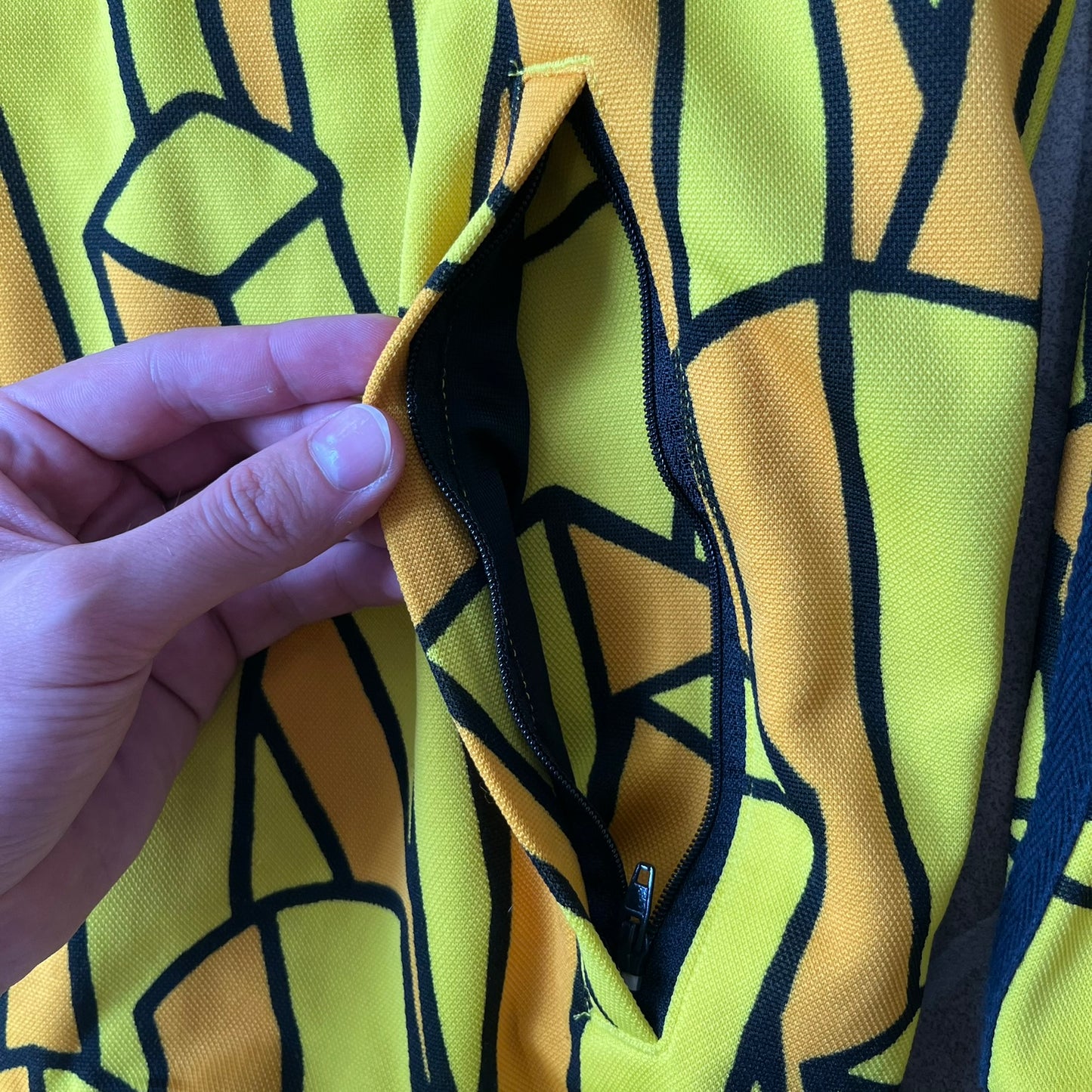 Adidas Originals x Jeremy Scott 2010 French Fry Track Jacket features an all-over yellow and black cartoon French fries print. The jacket is detailed with black Three Stripes along the sleeves, a small embroidered Trefoil logo on the chest, and a large black Trefoil with Adidas text printed across the back.