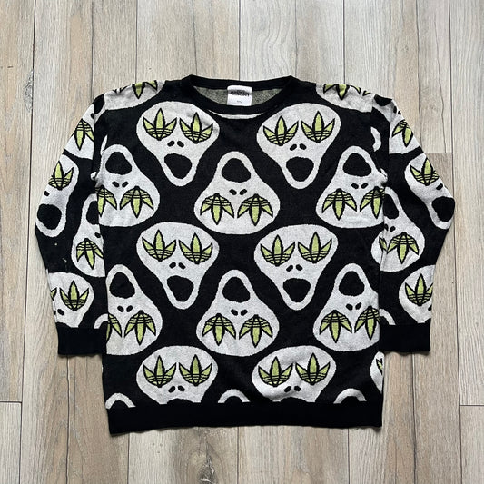 Adidas Jeremy Scott Alien Face 2012 Sweater features an all-over print of white alien faces arranged in alternating upright and upside-down patterns. The eyes of each alien are replaced with green Adidas Originals logos, creating a distinctive graphic design.
