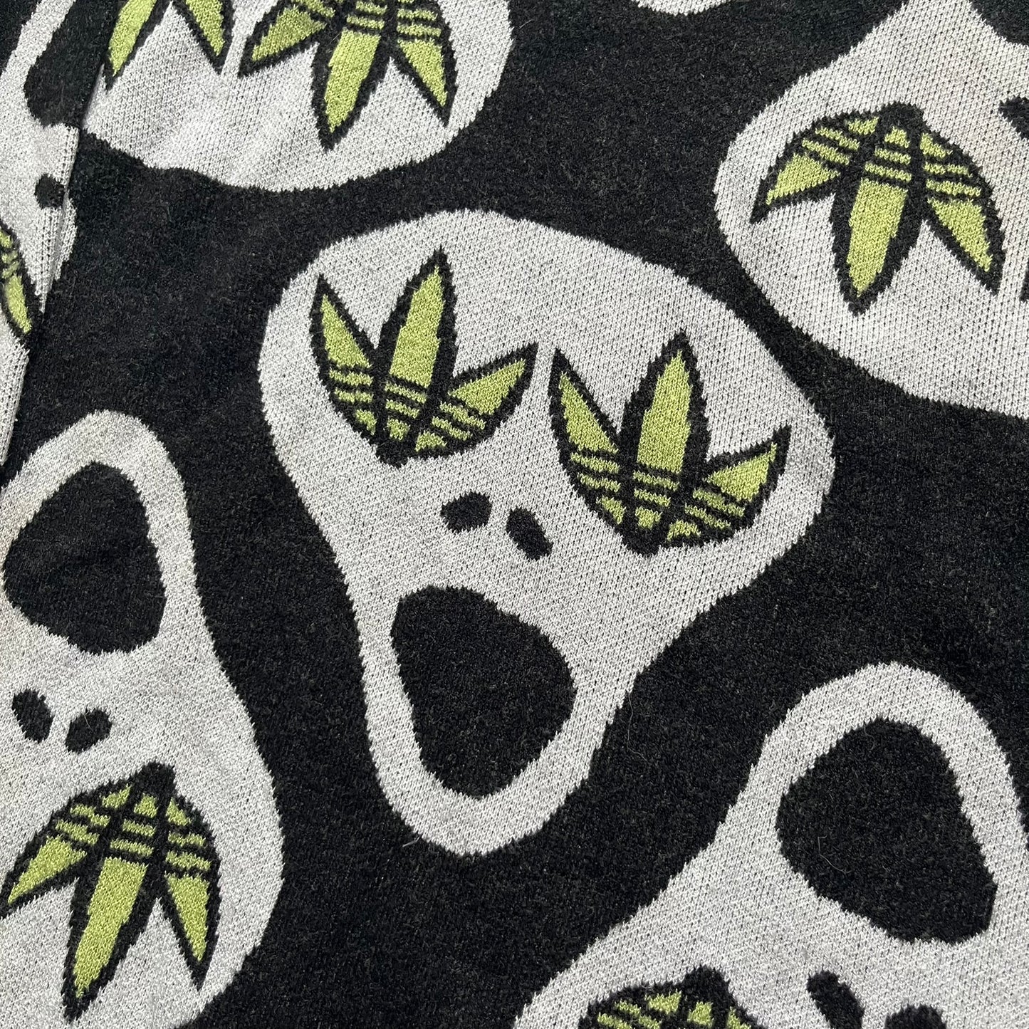 Adidas Jeremy Scott Alien Face 2012 Sweater features an all-over print of white alien faces arranged in alternating upright and upside-down patterns. The eyes of each alien are replaced with green Adidas Originals logos, creating a distinctive graphic design.