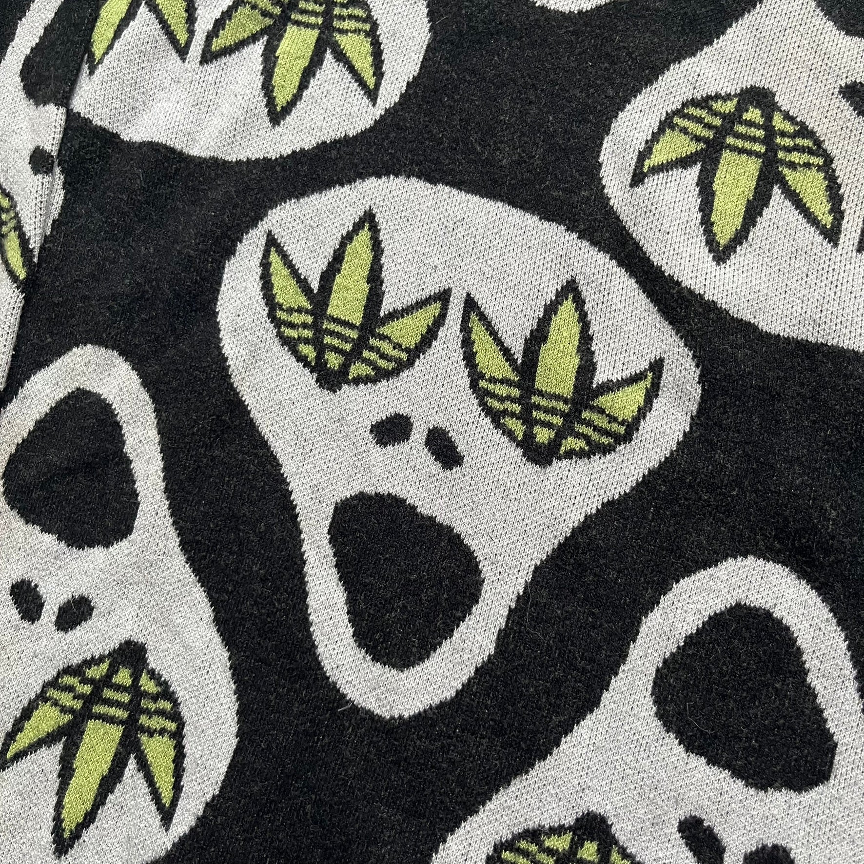 Adidas Jeremy Scott Alien Face 2012 Sweater features an all-over print of white alien faces arranged in alternating upright and upside-down patterns. The eyes of each alien are replaced with green Adidas Originals logos, creating a distinctive graphic design.