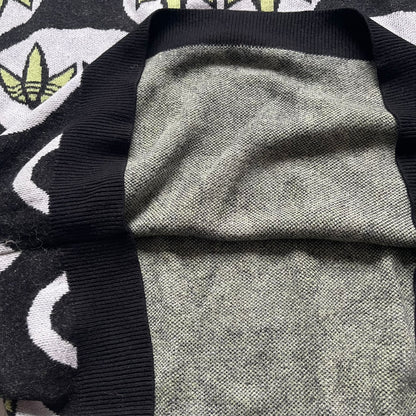 Adidas Jeremy Scott Alien Face 2012 Sweater features an all-over print of white alien faces arranged in alternating upright and upside-down patterns. The eyes of each alien are replaced with green Adidas Originals logos, creating a distinctive graphic design.