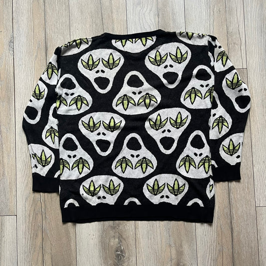 Adidas Jeremy Scott Alien Face 2012 Sweater features an all-over print of white alien faces arranged in alternating upright and upside-down patterns. The eyes of each alien are replaced with green Adidas Originals logos, creating a distinctive graphic design.