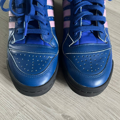 The Adidas Jeremy Scott Motorsport Wings 4.0 features a leather upper in blue with a gradient transitioning to green, accented by shock pink and light pink logo stripes. This high-top sneaker includes breathable perforations, a grippy rubber outsole, padded tongue, and signature Wings detailing at the collar. Released in 2022, the limited edition model comes with its original box and is crafted for comfort and style.