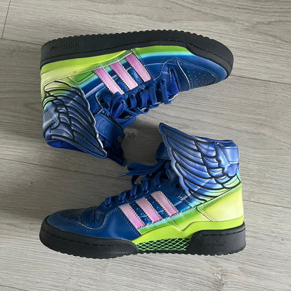 The Adidas Jeremy Scott Motorsport Wings 4.0 features a leather upper in blue with a gradient transitioning to green, accented by shock pink and light pink logo stripes. This high-top sneaker includes breathable perforations, a grippy rubber outsole, padded tongue, and signature Wings detailing at the collar. Released in 2022, the limited edition model comes with its original box and is crafted for comfort and style.