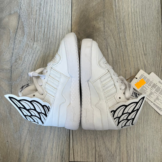 Adidas x Jeremy Scott Wings 4.0 Kids Sneakers were released on May 5, 2022. They feature white premium leather uppers with black Three Stripes, black heel tabs, and Jeremy Scott Wings branding. The high-top design includes a padded collar and tongue, along with a rubber herringbone outsole. One shoe is bigger than the other, making it primarily suitable as a display or collectible item.
