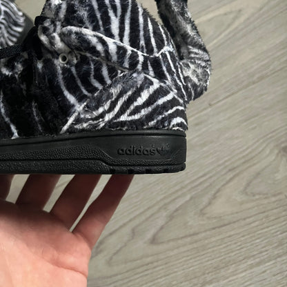 Adidas Jeremy Scott Zebra Black &amp; White Sneakers - Sample pair, Style G95749. High-top sneakers featuring black and white faux-fur zebra print, a 3D tail at the heel, rubber soles, and front lace closure. From the FW13 Jeremy Scott for Adidas collection, these iconic sneakers combine classic adidas design with signature crazy JS styling.
