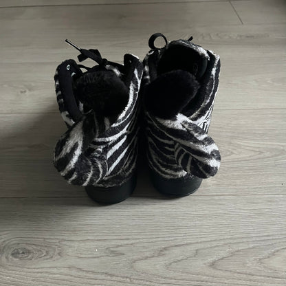 Adidas Jeremy Scott Zebra Black &amp; White Sneakers – Sample pair, Style G95749. High-top sneakers featuring black and white faux-fur zebra print, a 3D tail at the heel, rubber soles, and front lace closure. From the FW13 Jeremy Scott for Adidas collection, these iconic sneakers combine classic adidas design with signature crazy JS styling.&nbsp;