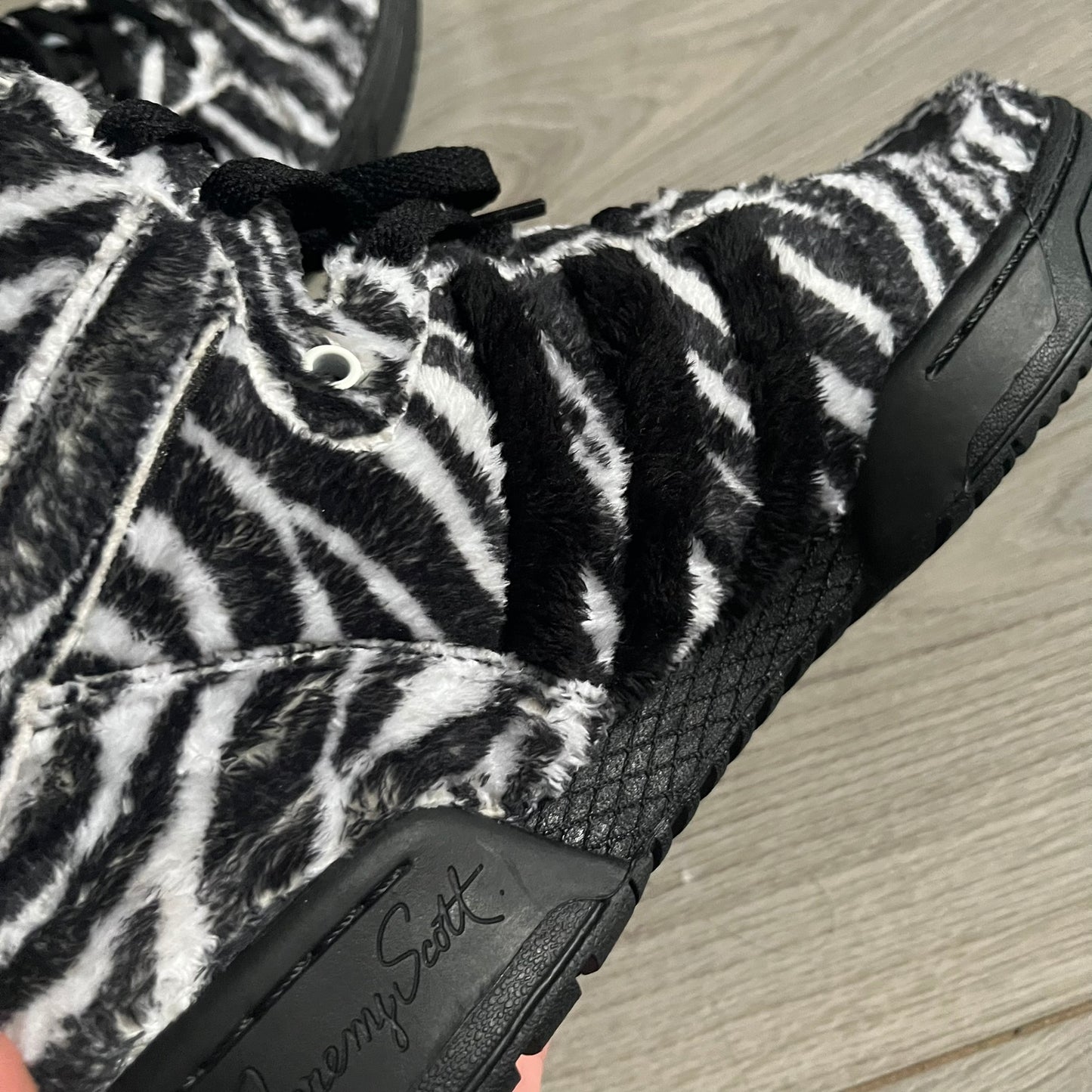 Adidas Jeremy Scott Zebra Black &amp; White Sneakers – Sample pair, Style G95749. High-top sneakers featuring black and white faux-fur zebra print, a 3D tail at the heel, rubber soles, and front lace closure. From the FW13 Jeremy Scott for Adidas collection, these iconic sneakers combine classic adidas design with signature crazy JS styling.&nbsp;