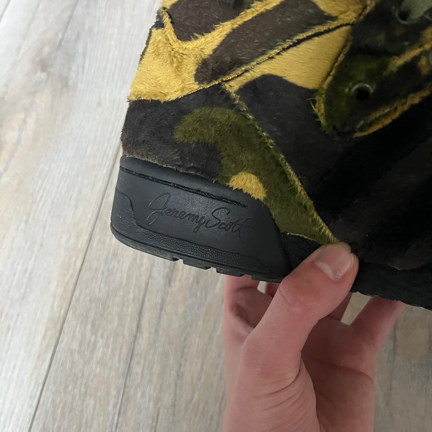 Adidas Jeremy Scott “Camo Bear” Sneakers (Style Q20917) released on March 16, 2013, in Earth Green/Black/Shioli. Featuring plush fleece uppers with a camouflage pattern, black three stripes, and a fully stuffed teddy bear head and arms on the tongue. Includes Jeremy Scott signature detailing on the inside heel and a black rubber sole.