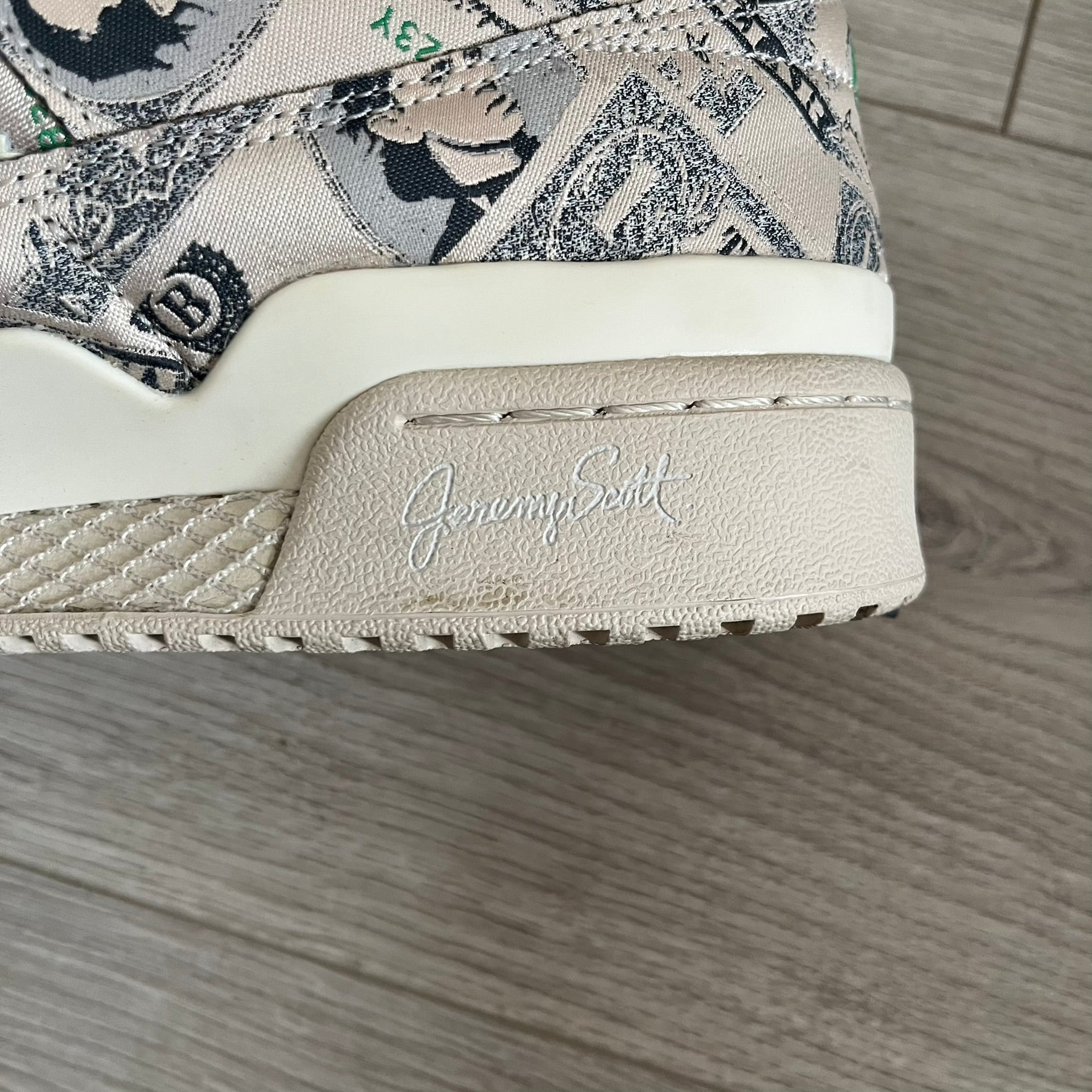 Adidas Jeremy Scott x Forum Wings 1.0 Low Money, style GX6393, in a Bliss/Off White/Bliss colorway. This pair features a textile upper covered in Jeremy Scott’s signature currency-themed graphic, swapping George Washington’s portrait for his own. The iconic 3D wings sit on the side of the shoe, with embossed adidas branding and Scott’s signature on opposite panels. Built with an EVA wedge for lightweight cushioning and a durable rubber cup sole. First released on October 21, 2021.