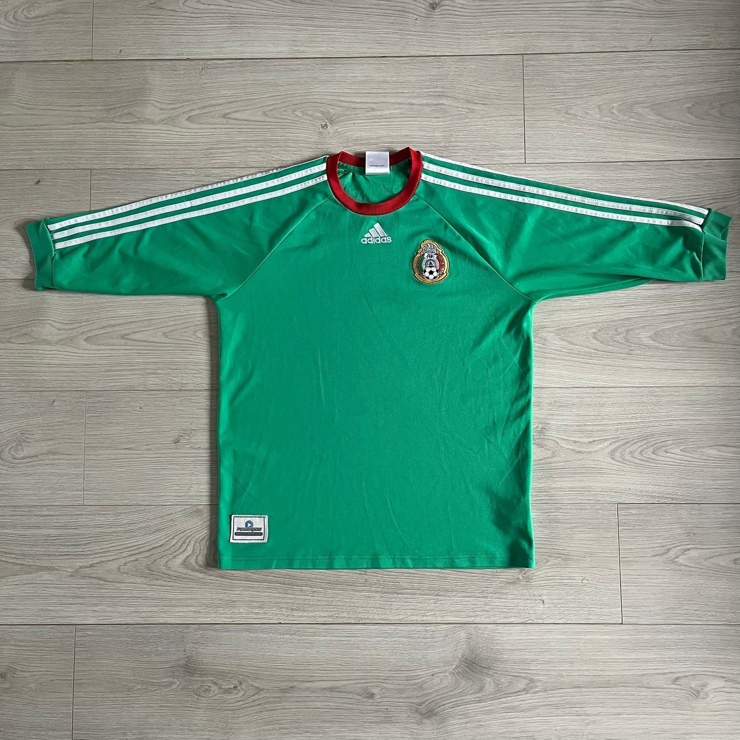 Adidas 2007-08 Mexico Powerade Limited Edition 3/4 Tee in green with red collar and white Adidas sleeve stripes. Features embroidered Adidas logo beneath the neck, Mexico crest on the heart, and a “Powerade Edición Especial” patch at the lower front. Extremely rare, issued only to select Coca-Cola store owners in Mexico.