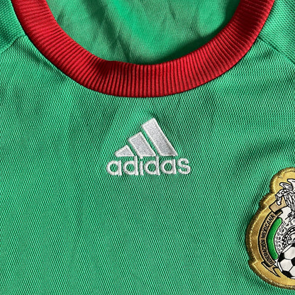 Adidas 2007-08 Mexico Powerade Limited Edition 3/4 Tee in green with red collar and white Adidas sleeve stripes. Features embroidered Adidas logo beneath the neck, Mexico crest on the heart, and a “Powerade Edición Especial” patch at the lower front. Extremely rare, issued only to select Coca-Cola store owners in Mexico.