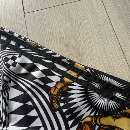 Close-up of a black and white patterned fabric with butterfly design on a wooden floor.