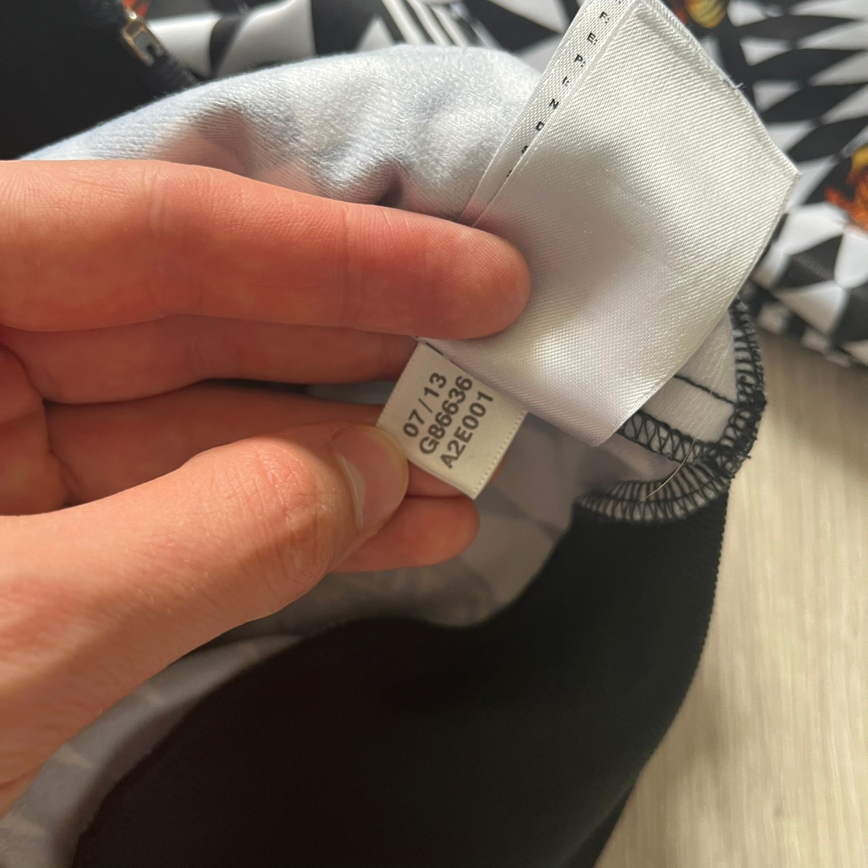 Hand holding a cap with a visible brand label on a blurred background