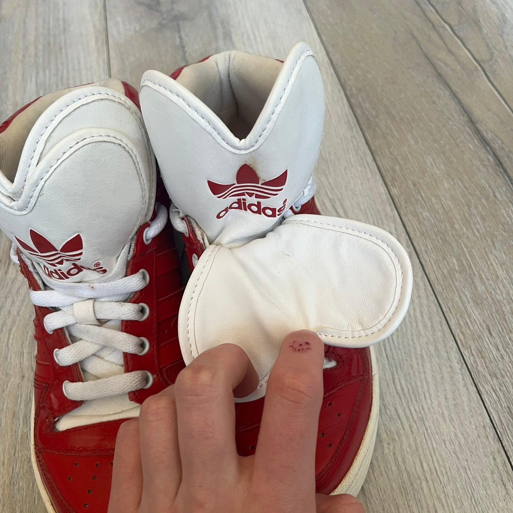 Adidas Originals Metro Attitude Logo Heart Sneakers are women’s sneakers released in 2012, featuring a red suede upper with matching University-Red accents. The design includes dual heart-shaped tongues in white with red Adidas logos, paired with a white sole and laces. Metro Attitude Logo Heart W model (G61014) inspired by Jeremy Scott collaborations.