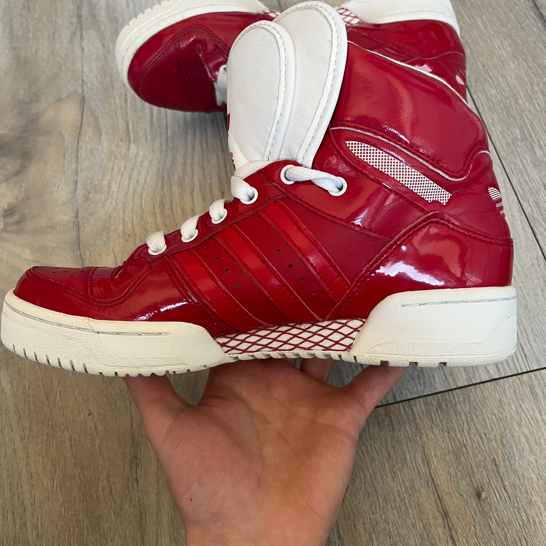 Adidas Originals Metro Attitude Logo Heart Sneakers are women’s sneakers released in 2012, featuring a red suede upper with matching University-Red accents. The design includes dual heart-shaped tongues in white with red Adidas logos, paired with a white sole and laces. Metro Attitude Logo Heart W model (G61014) inspired by Jeremy Scott collaborations.