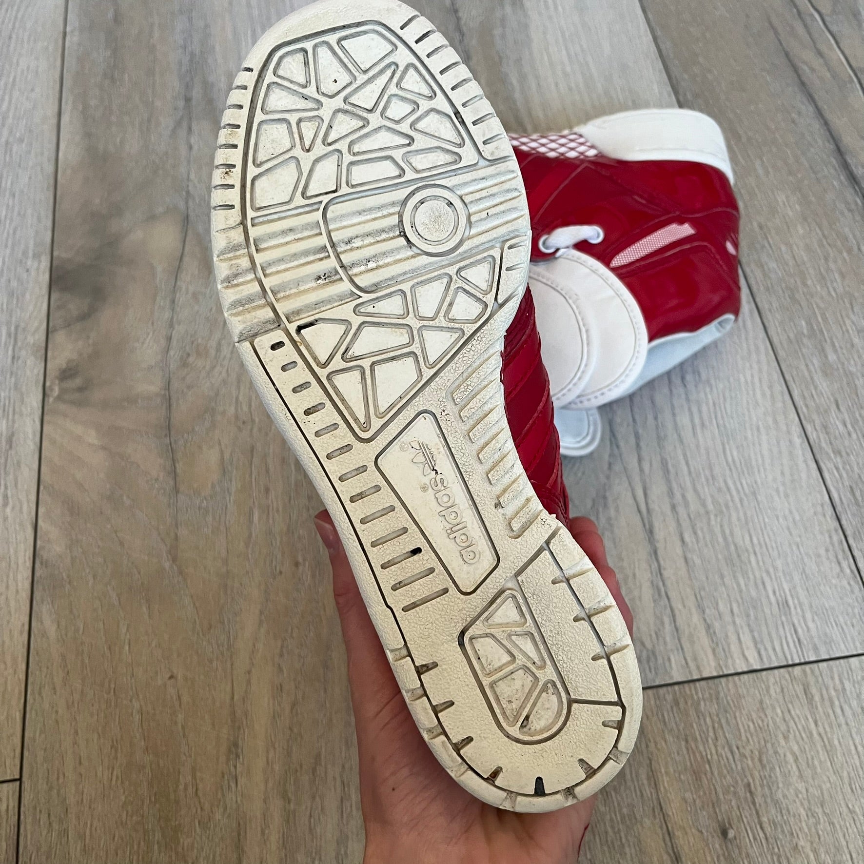 Adidas Originals Metro Attitude Logo Heart Sneakers are women’s sneakers released in 2012, featuring a red suede upper with matching University-Red accents. The design includes dual heart-shaped tongues in white with red Adidas logos, paired with a white sole and laces. Metro Attitude Logo Heart W model (G61014) inspired by Jeremy Scott collaborations.