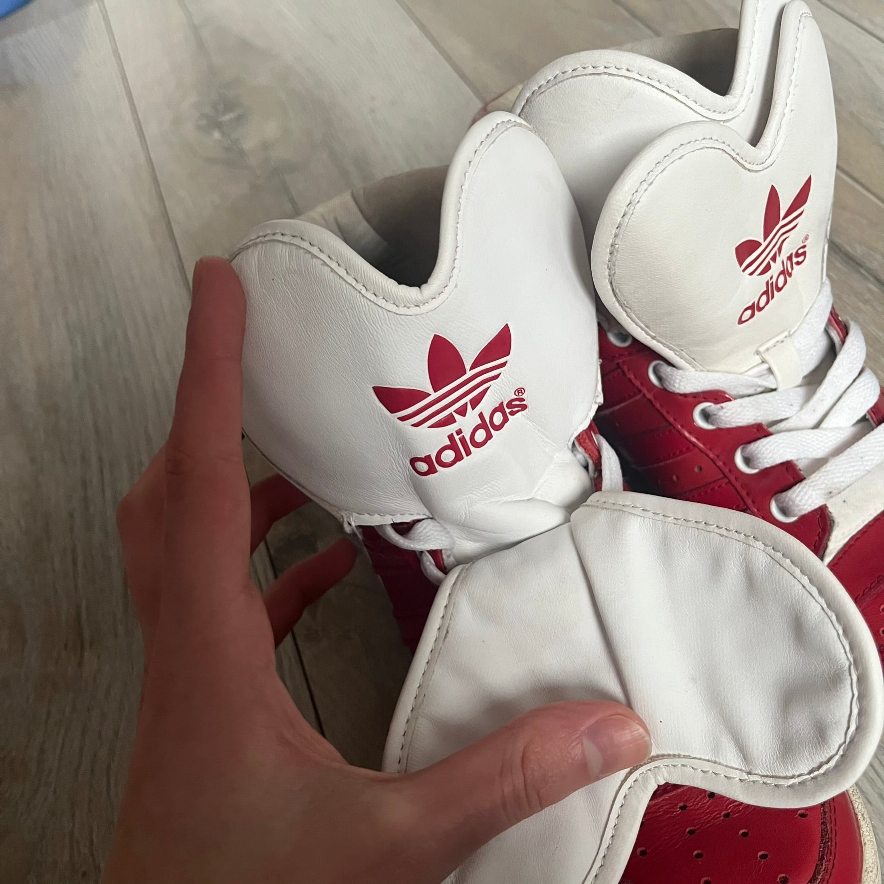 Adidas Originals Metro Attitude Logo Heart Sneakers are women’s sneakers released in 2012, featuring a red suede upper with matching University-Red accents. The design includes dual heart-shaped tongues in white with red Adidas logos, paired with a white sole and laces. Metro Attitude Logo Heart W model (G61014) inspired by Jeremy Scott collaborations.