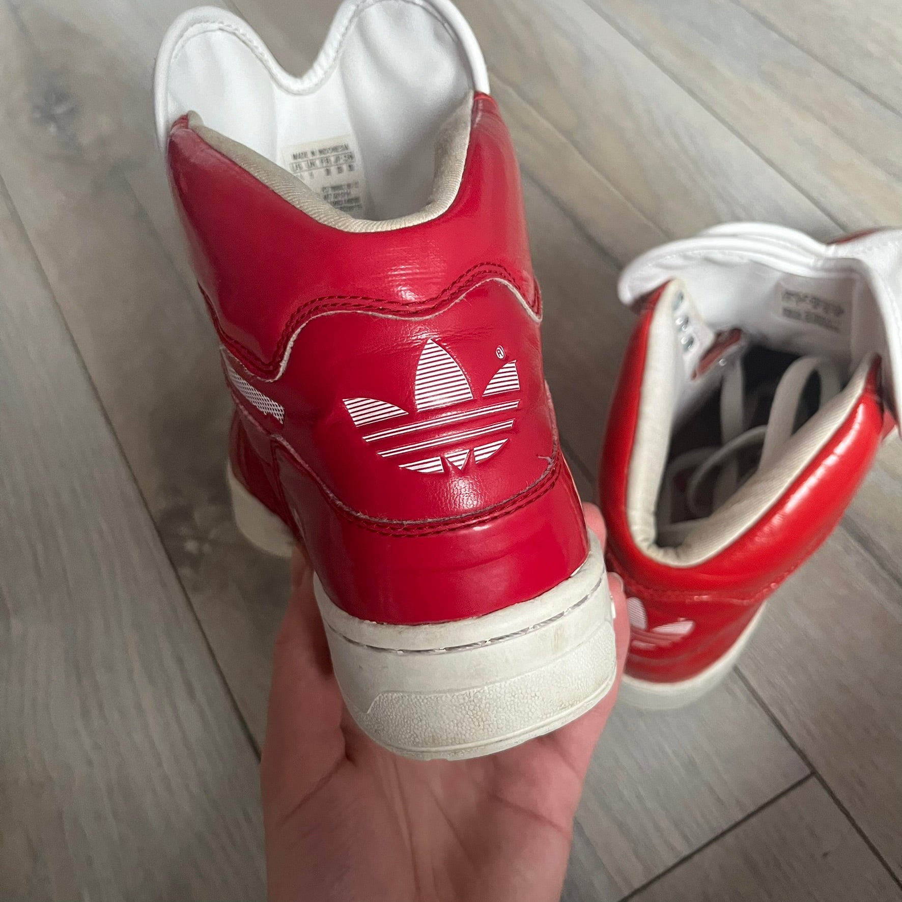 Adidas Originals Metro Attitude Logo Heart Sneakers are women’s sneakers released in 2012, featuring a red suede upper with matching University-Red accents. The design includes dual heart-shaped tongues in white with red Adidas logos, paired with a white sole and laces. Metro Attitude Logo Heart W model (G61014) inspired by Jeremy Scott collaborations.