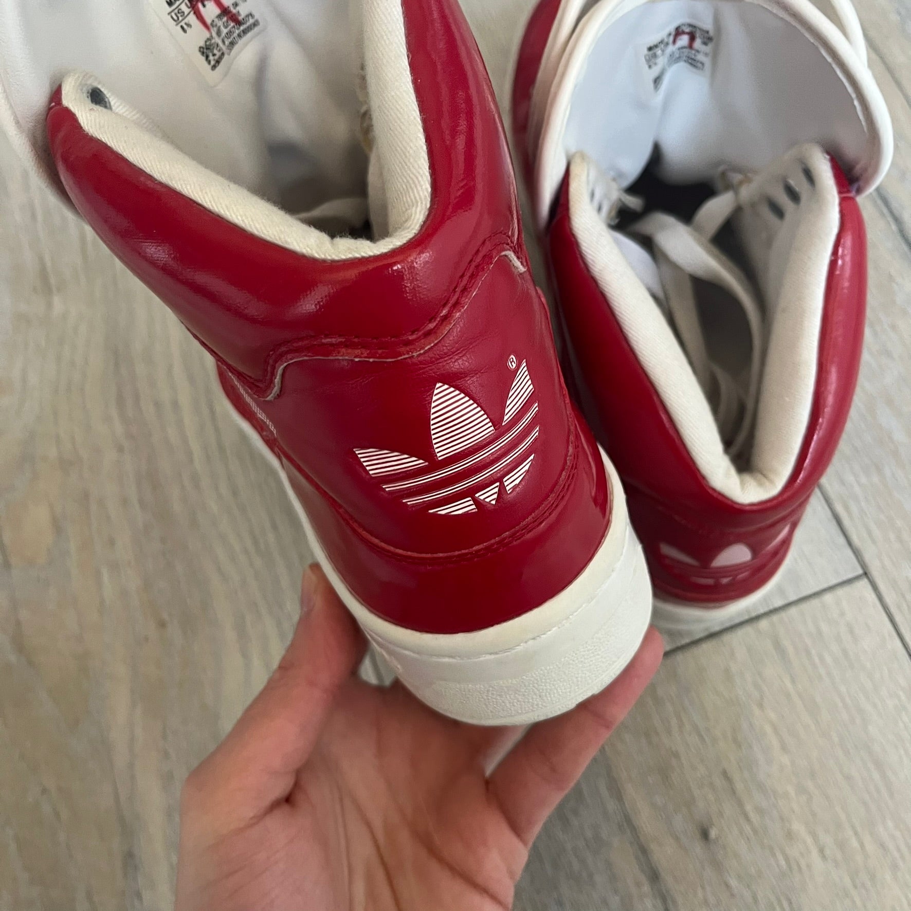 Adidas Originals Metro Attitude Logo Heart Sneakers are women’s sneakers released in 2012, featuring a red suede upper with matching University-Red accents. The design includes dual heart-shaped tongues in white with red Adidas logos, paired with a white sole and laces. Metro Attitude Logo Heart W model (G61014) inspired by Jeremy Scott collaborations